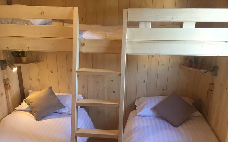 Chambre avec lit superposé du chalet, en location au camping Les Murmures du Lignon à Tence