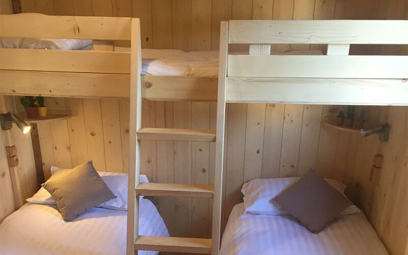 Chambre avec lit superposé de la grande cabane, en location au camping Les Murmures du Lignon en Auvergne