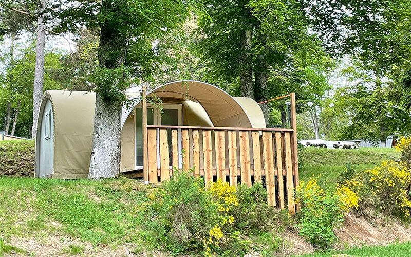 Vue extérieure de la Mini-tente Nomade avec terrasse, en location hébergement insolite en Auvergne, au camping Les Murmures du Lignon