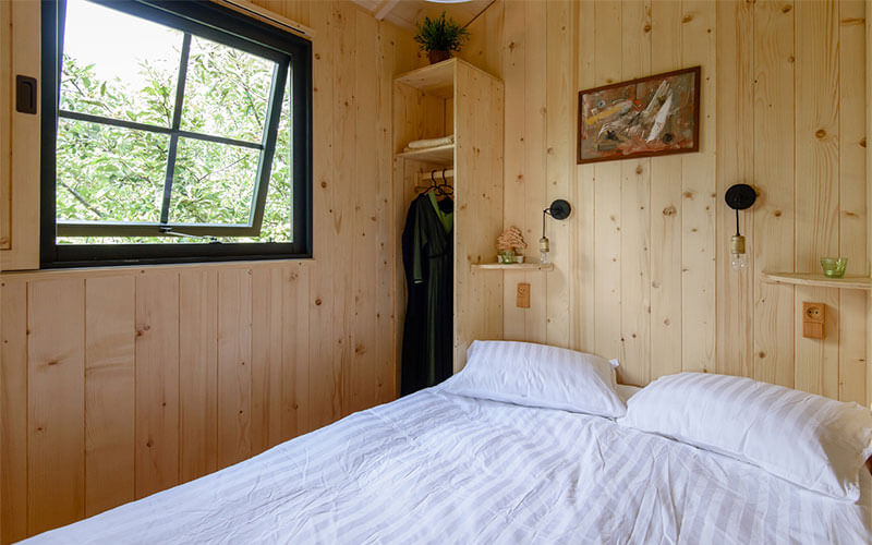 Chambre avec lit deux personnes de la petite cabane au camping Les Murmures du Lignon en Auvergne