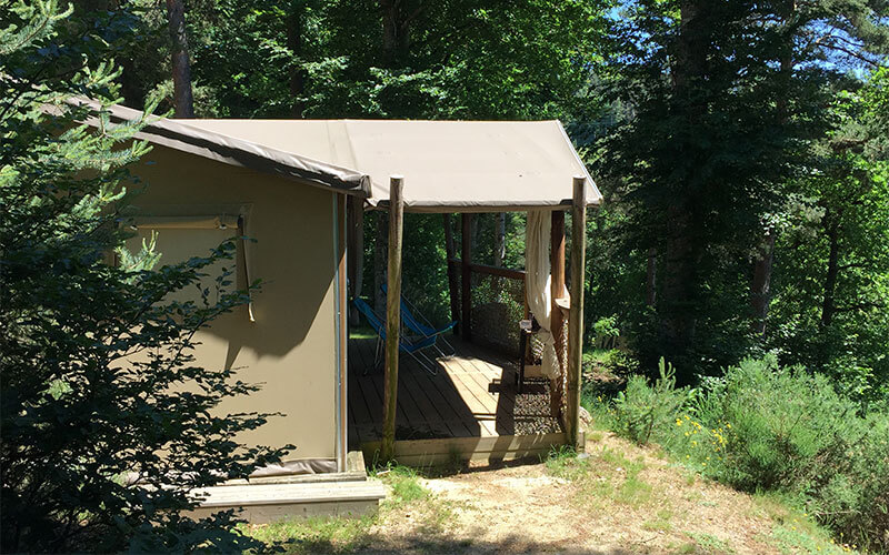 Vue extérieure de la terrasse de la tente Safari Cotton en location au camping Les Murmures du Lignon à Tence